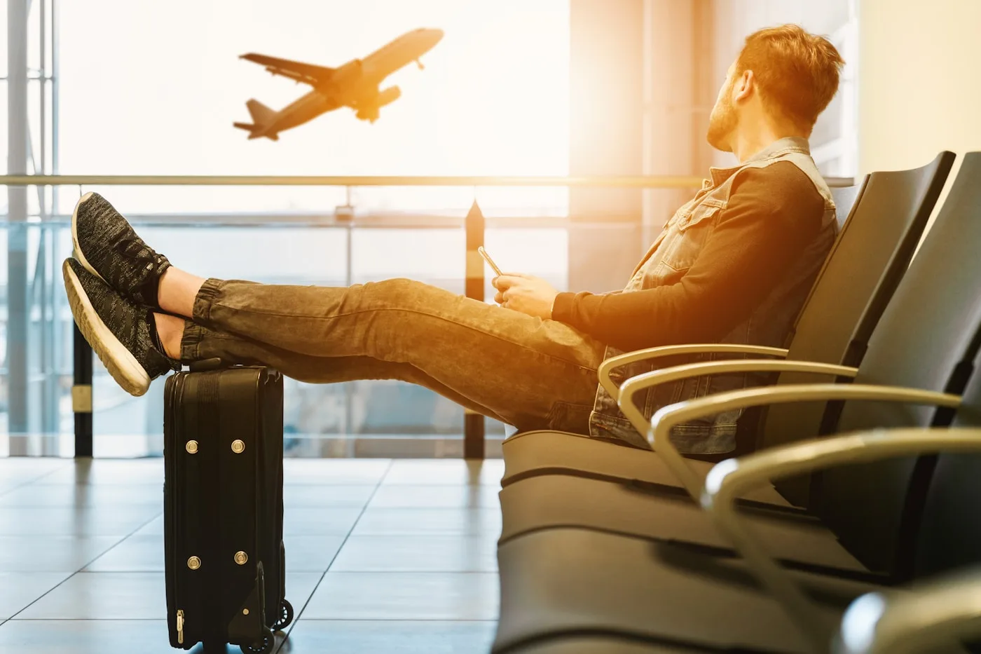 Solo traveler resting with luggage in an airport terminal